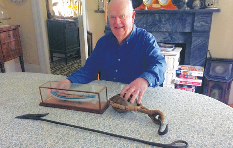 Historian Renny Stackpole poses with some of the implements used in whaling.