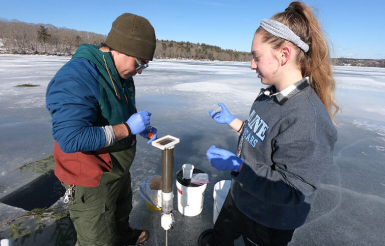 UMaine graduate students Grayson Hutson and Julia Sunnarborg collecting an eDNA sample through the ice at Walker Pond. Grayson and Julia and colleagues at the University of Maine and University of Southern Maine are using eDNA to study migration patterns of alewives as they move between saltwater and freshwater to understant their affects on lake and estuary ecosystems, especially in cases where dams are being removed to increase fish passage. They are even mining the lake sediments for ancient eDNA to understand what fish populations might have looked like in the past.