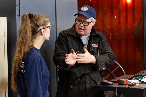 Aliza Gamage is given direction by her instructor, Tom Brungardt, in the welding and metal fabrication shop.