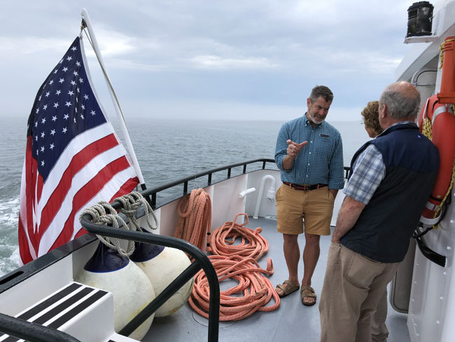 Douglas Cornman chats with passengers on the stern. PHOTO: TOM GROENING