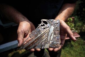 Clint Jones holding a piece of his art