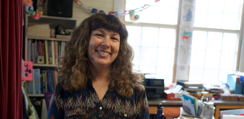 woman in a classroom smiling