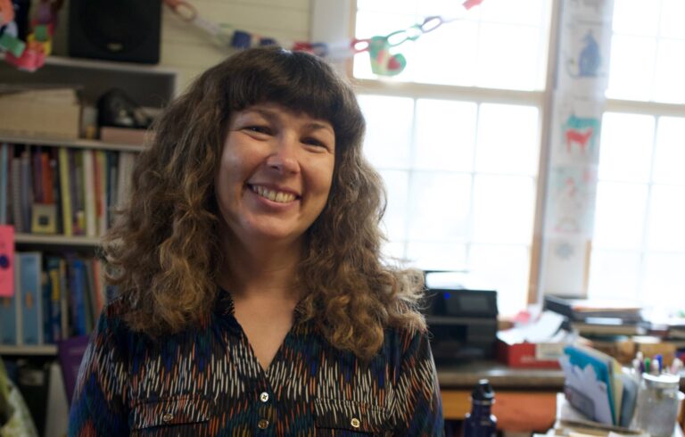 woman in a classroom smiling