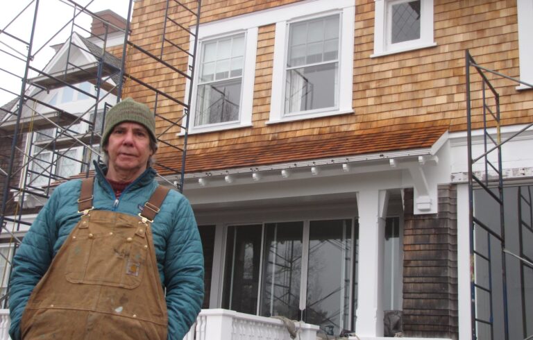 man standing in front of house with scaffolding