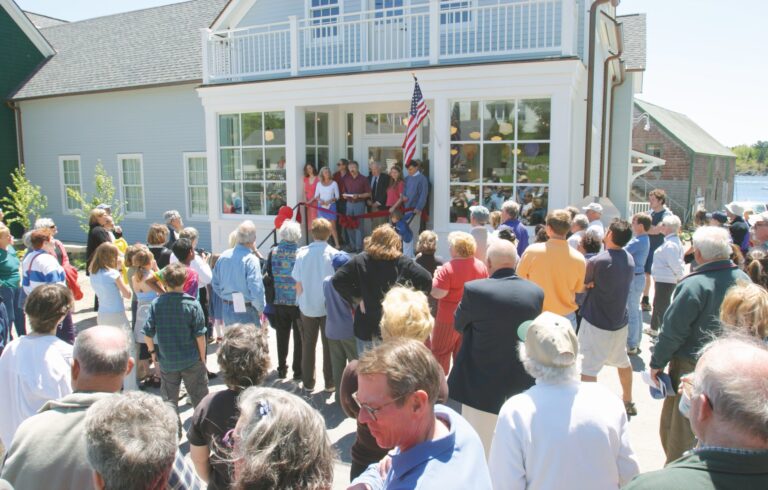 crowd standing in front of building at community center opening ceremony