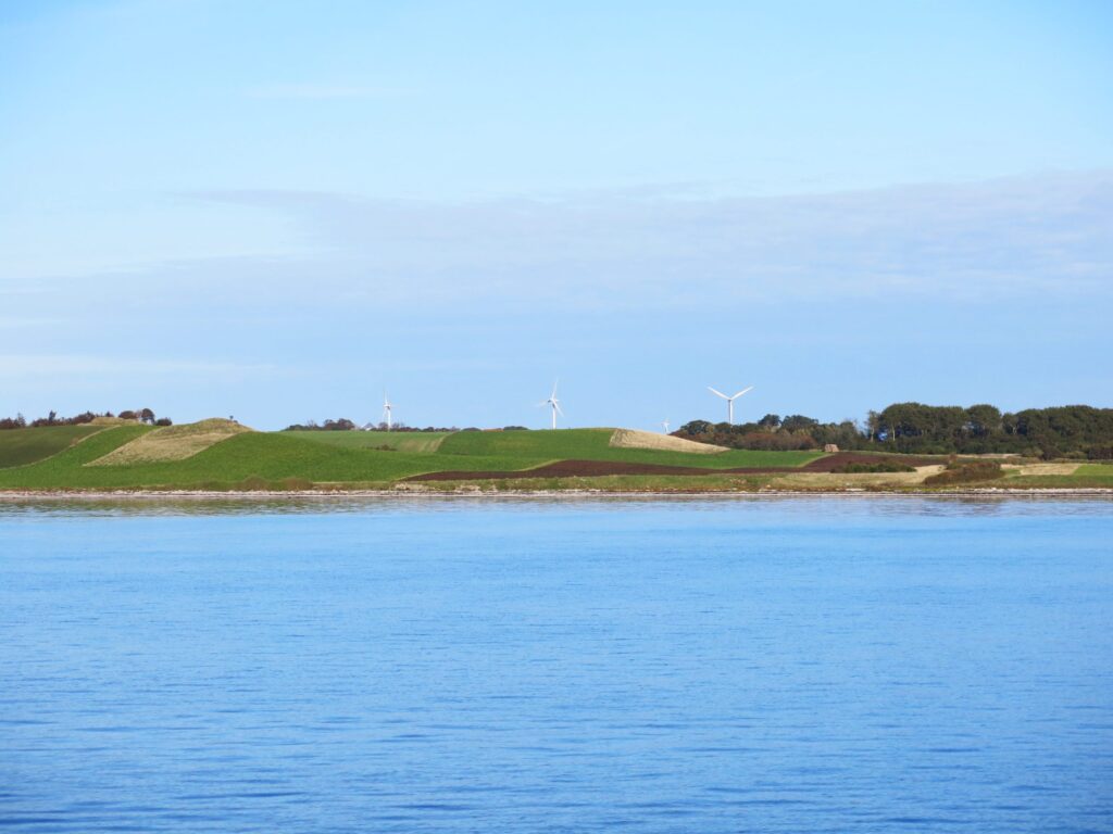 windmills in the distance behind a body of water