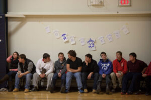 spectators seated on the sideline of a basketball game