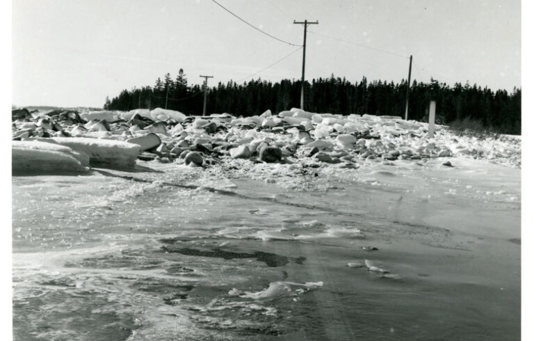 An undated photograph by LaRue Spiker shows snow and ice-encrusted rocks strewn over the Seawall Road.