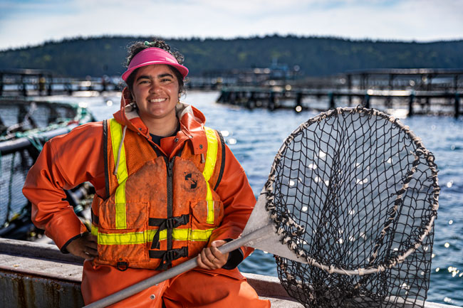 Susana DeFrank, a fish health technician with Cooke USA, works with a dip net at a Machias Bay salmon farm. PHOTO: COURTESY COOKE INC.