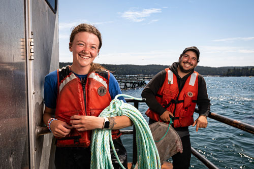 Cooke USA Fish Health Technician Jaelyn Matthews and Alex Johndro of New DHC Inc. at a Machias Bay salmon farm. PHOTO: COURTESY COOKE INC.