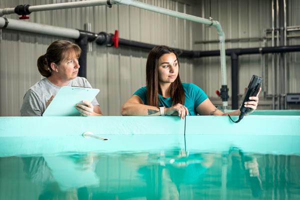 Cooke Inc.’s hatchery manager Jen Ford (left) and hatchery technician Megan Cote in Eastport. PHOTO: COURTESY COOKE INC.