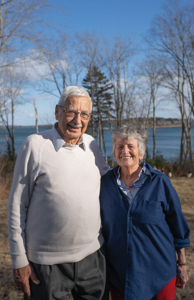 a smiling couple in front of the ocean