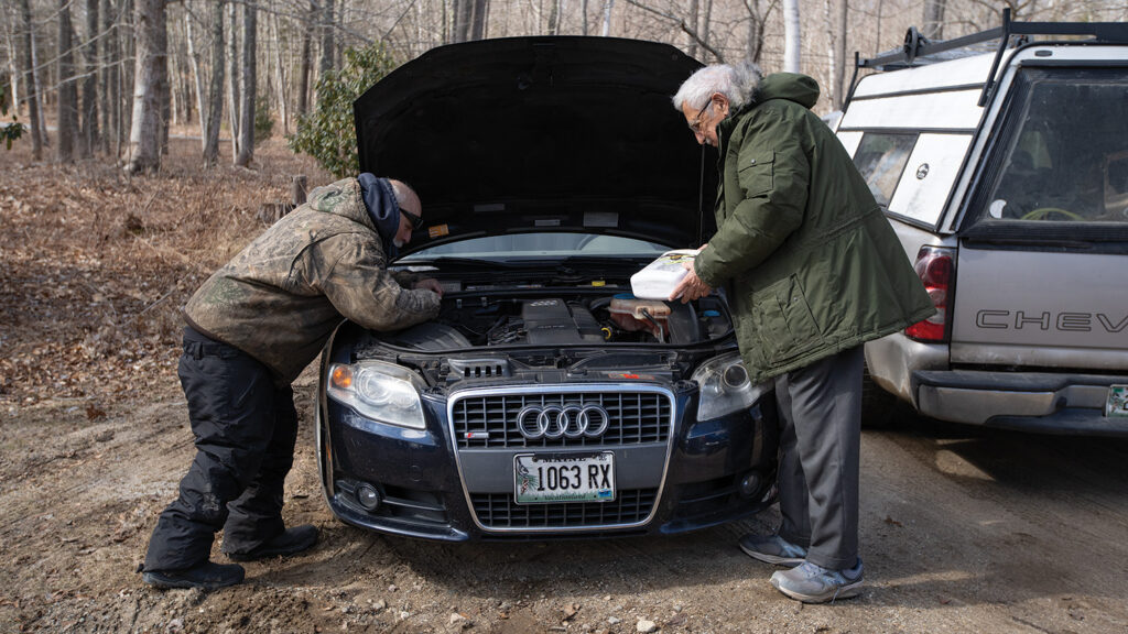 two men work on a car