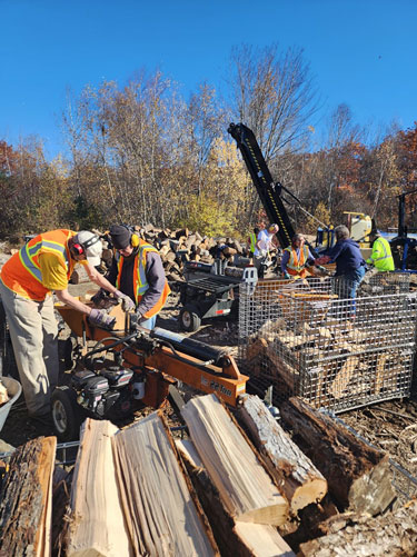 Volunteers with the Waldo County Woodshed split wood in Searsmont.